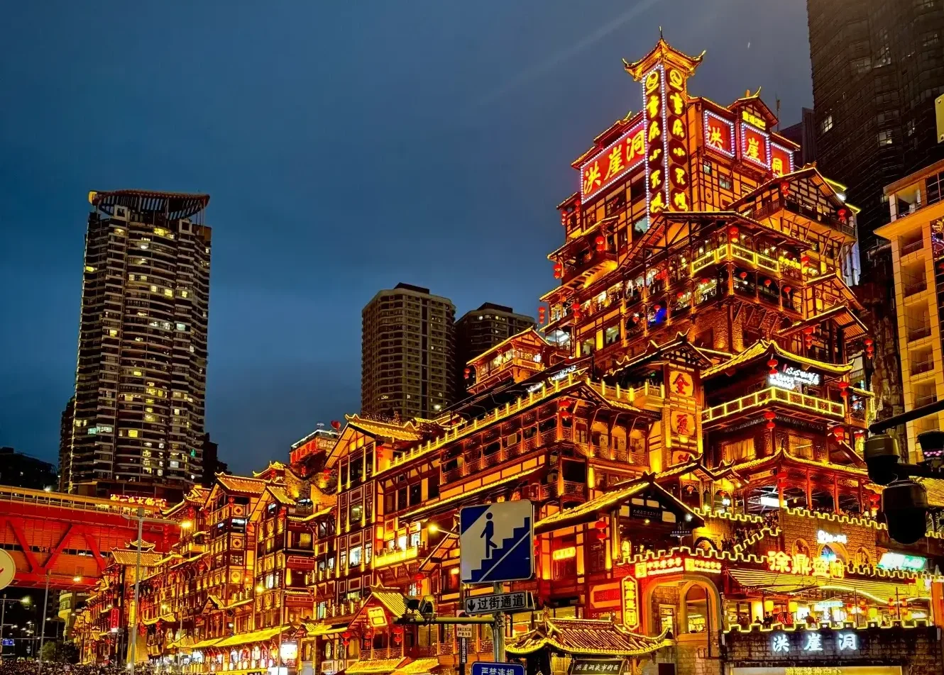 Home 5 Hongyadong, a renowned attraction in Chongqing, glows with warm yellow lights illuminating the entire structure at night.